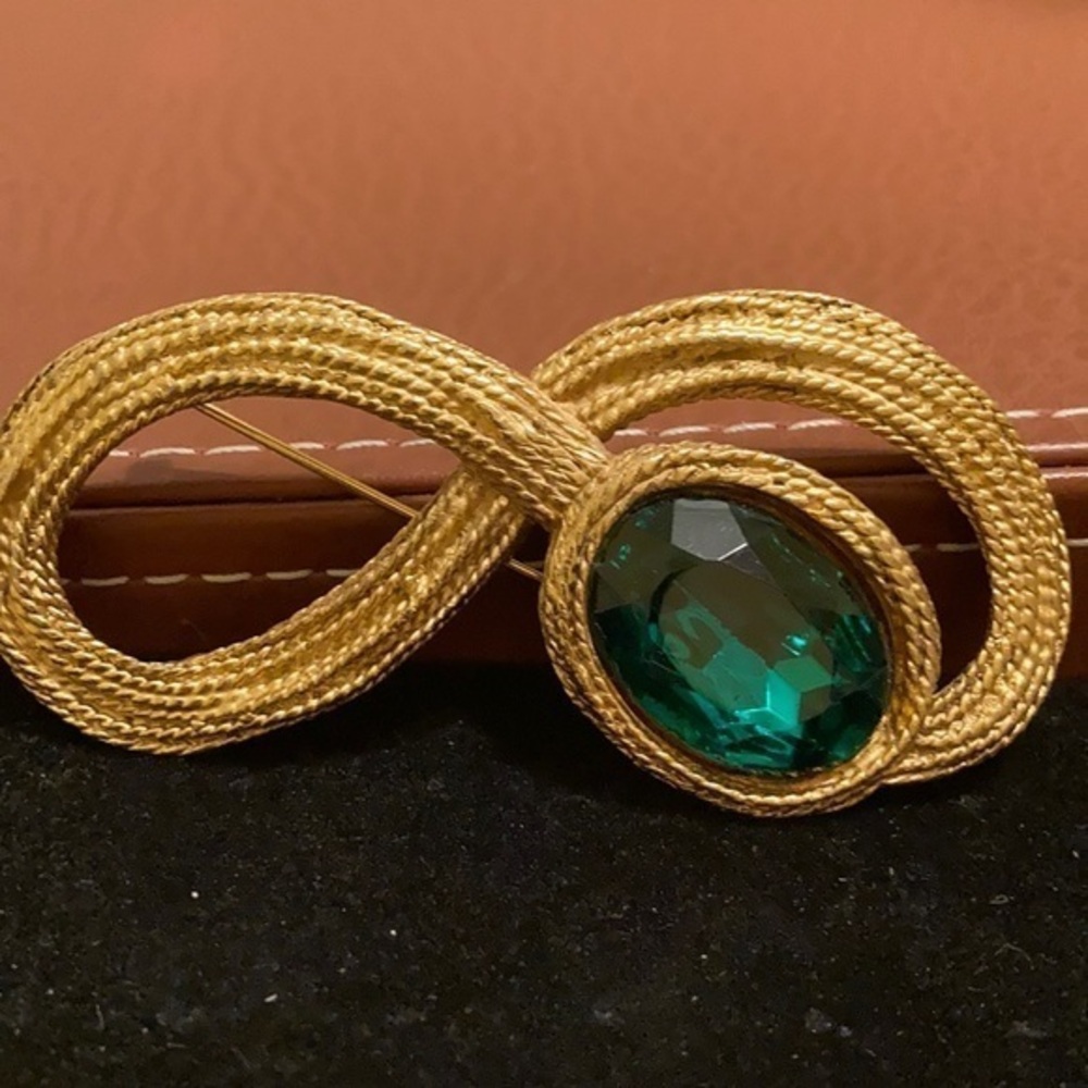 Vintage gold tone textured figure 8 statement brooch with faux emerald gemstone